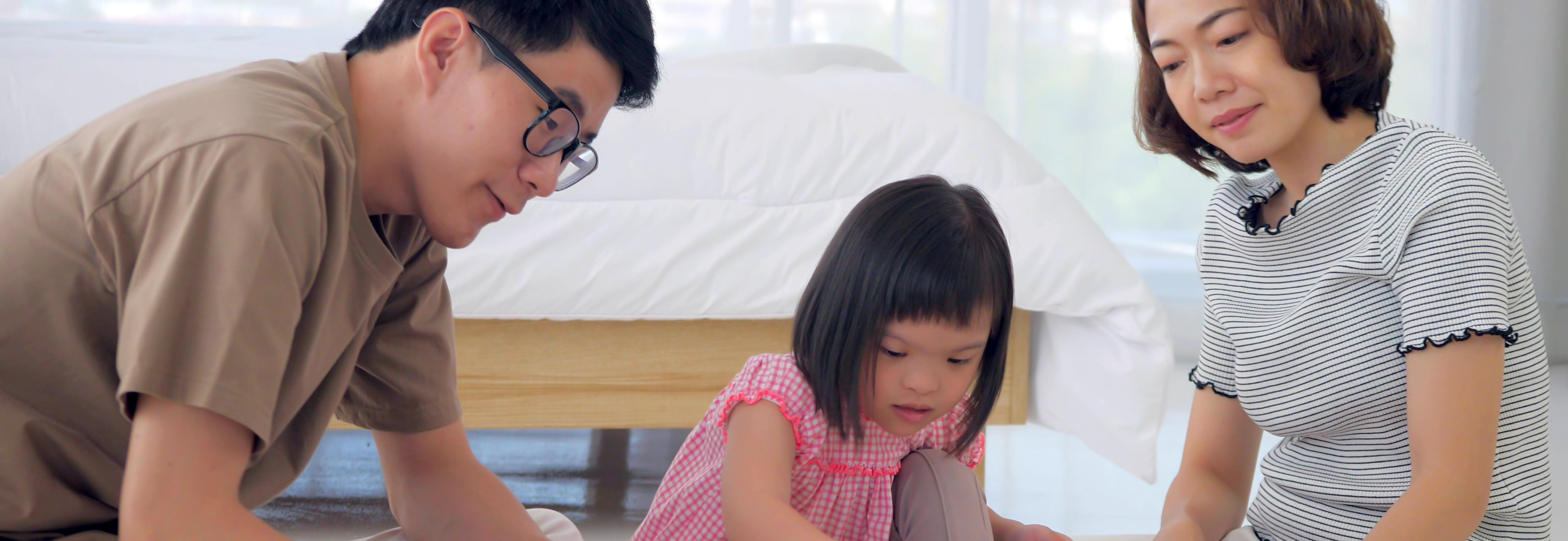 Young girl and her parents playing with blocks